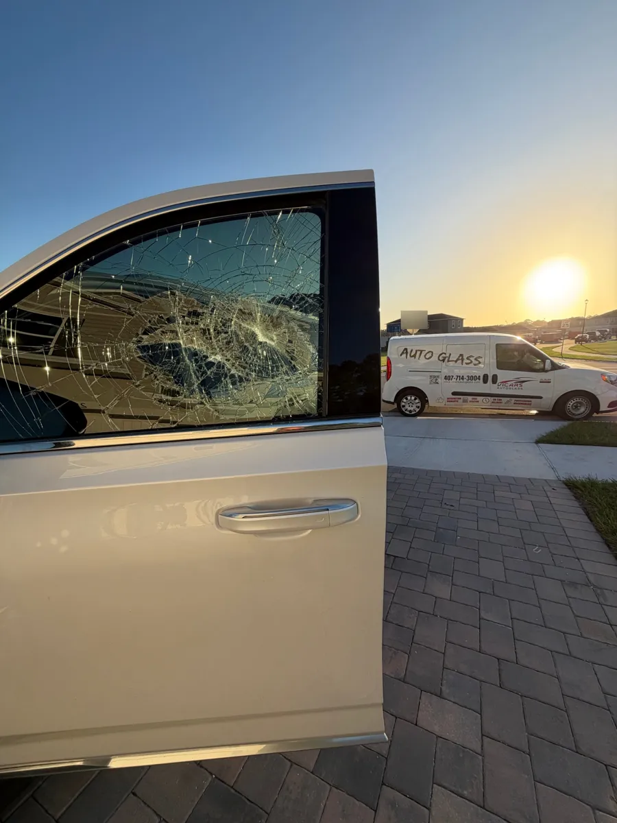 Cracked front door glass on a Cadillac Escalade with the ViCars AutoGlass van in Clermont, FL