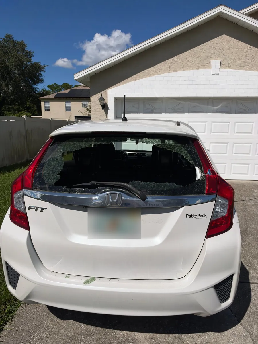 Shattered back glass on a Honda Fit in a driveway in Union Park, FL