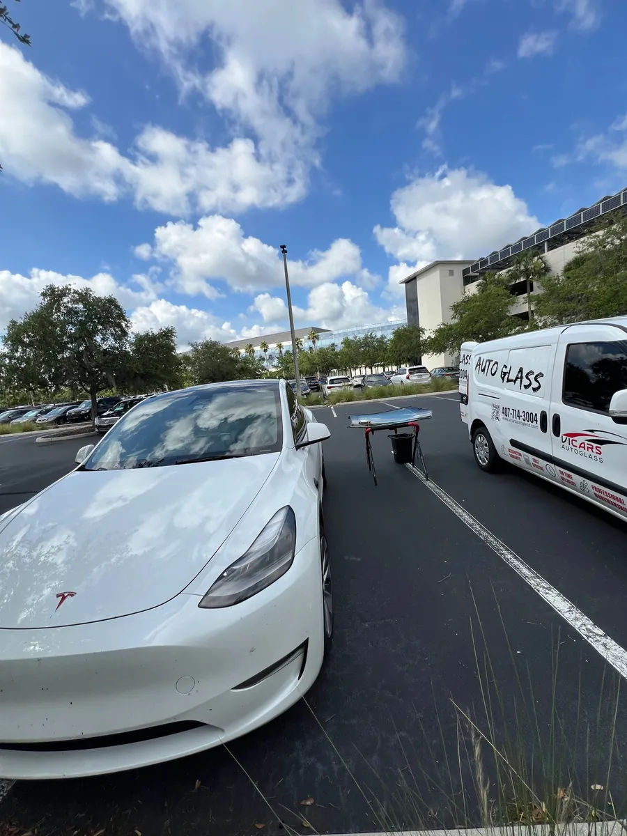 ViCars AutoGlass van next to a Tesla Model Y during a mobile windshield replacement in Winter Garden, FL