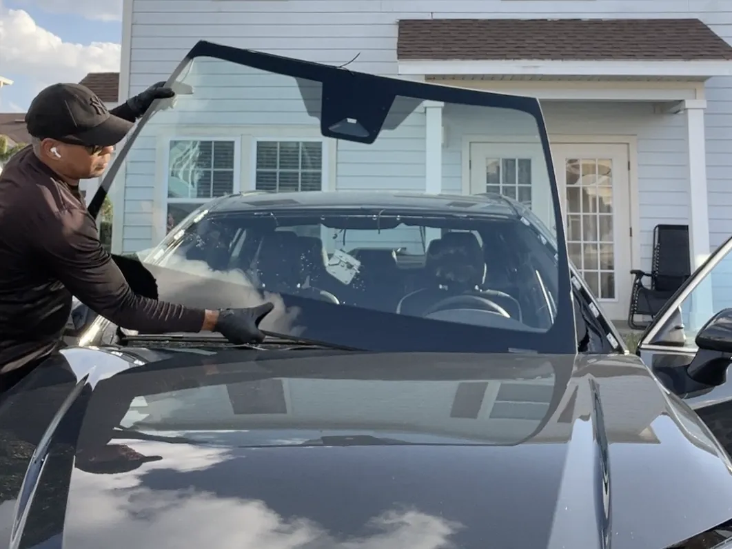 ViCars technician replacing the windshield of a 2026 Toyota Camry in a customer's driveway in Orlando, FL