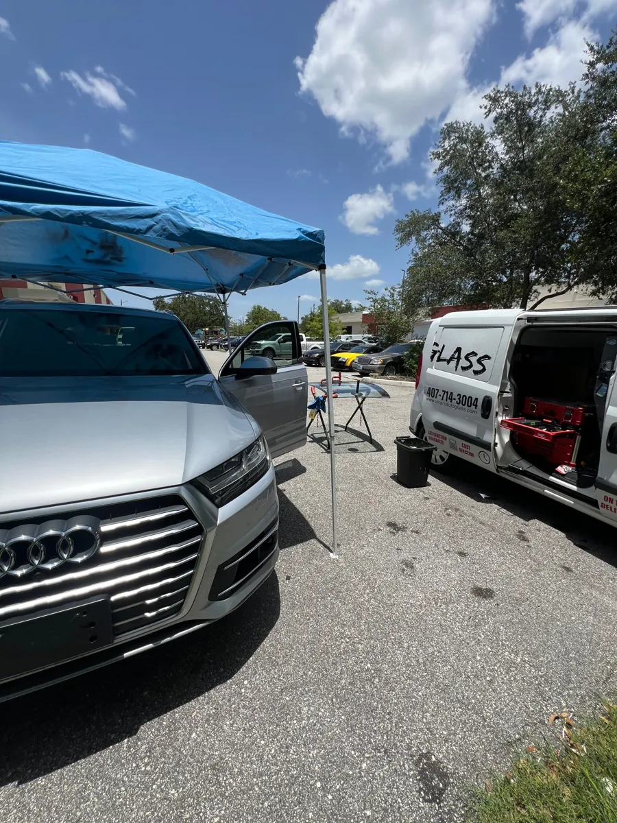 ViCars AutoGlass van and canopy next to an Audi Q7 during windshield replacement in St. Cloud, FL