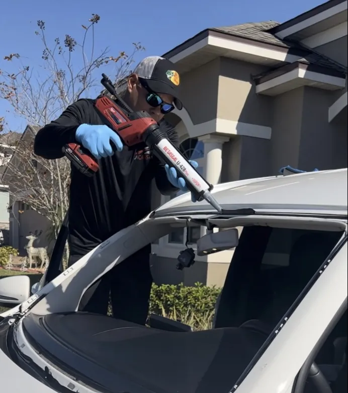 ViCars technician applying urethane to install a new windshield on a Mercedes-Benz in Kissimmee, FL